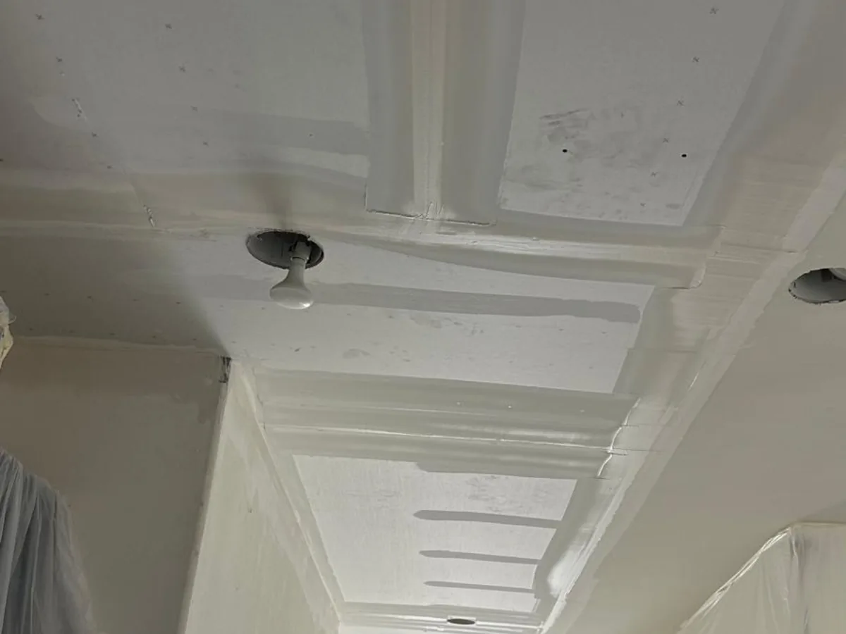 Ceiling beams coated in joint compound during drywall taping and mudding