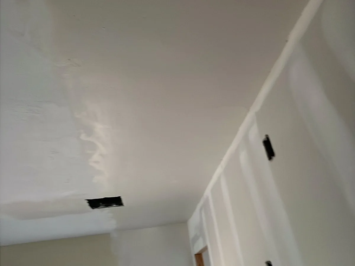 Smooth drywall finish where the wall meets the ceiling in a corner